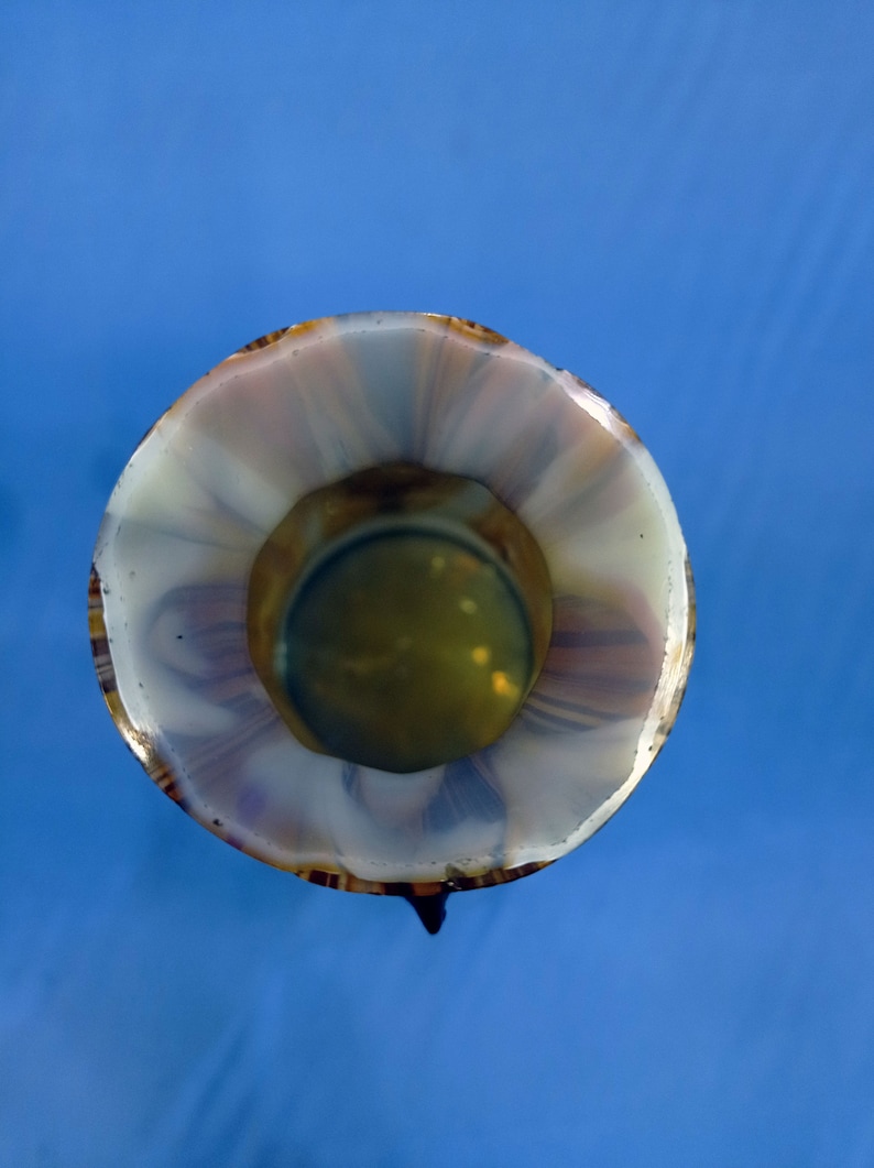 Puede incluir: Un jarr&oacute;n de vidrio blanco y marr&oacute;n con un patr&oacute;n de espiral. El jarr&oacute;n tiene una abertura ancha y una base estrecha.