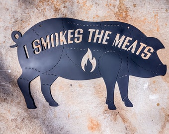 Puede incluir: Silueta de cerdo de metal negro con el texto "I SMOKES THE MEATS" y un diseño de llama.