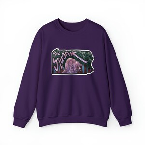 May include: Purple sweatshirt with a graphic of the Pennsylvania state outline featuring a pink creature labeled "The Squonk" with an arrow pointing to it.