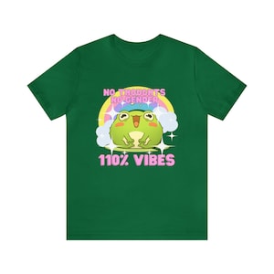 May include: Green t-shirt featuring a cartoon frog wearing a pink hat and a rainbow behind it. The text on the shirt reads "No thoughts no gender 110% vibes".