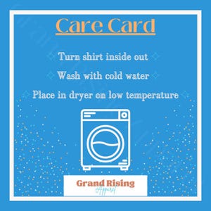 May include: A blue care card with white text and a white outline of a washing machine. The card reads "Care Card", "Turn shirt inside out", "Wash with cold water", and "Place in dryer on low temperature". The brand name "Grand Rising Apparel" is at the bottom.
