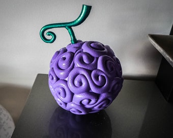 May include: A purple and green 3D printed model of the  "Gum-Gum Fruit" from the anime series One Piece. The fruit is a sphere with a swirling pattern and a green stem.