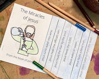 May include: A craft table scene with a stapler, pencils, and a booklet titled "The Miracles of Jesus." The booklet features an illustration of Jesus and lists his miracles. A basket of colored pencils sits nearby.