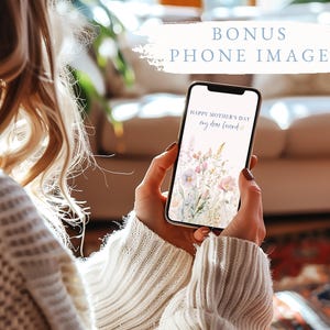 May include: A smartphone displays a floral Mother's Day greeting, held by a person wearing a cream-colored sweater. The phone's screen features pastel flowers and the text "Happy Mother's Day my dear friend". The image includes the text "BONUS PHONE IMAGE".