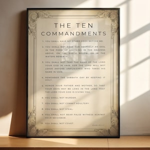 Puede incluir: Impresión enmarcada de "Los Diez Mandamientos" en un estilo vintage clásico. El texto se muestra en una fuente serif sobre un fondo beige, enmarcado con bordes decorativos. La impresión se exhibe sobre una superficie de madera.
