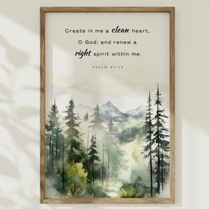 Puede incluir: Una pintura de acuarela de un bosque con una montaña en el fondo. La pintura está enmarcada en un marco marrón claro. El texto "Create in me a clean heart, O God; and renew a right spirit within me. PSALM 51:10" está impreso en la pintura.
