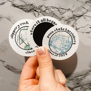 May include: Two round stickers with maps of Slippery Rock and Penn State Harrisburg. The stickers are white with black text and blue map details. The text on the Slippery Rock sticker reads "where it all began slippery rock class". The text on the Penn State Harrisburg sticker reads "penn state harrisburg class of 2024".