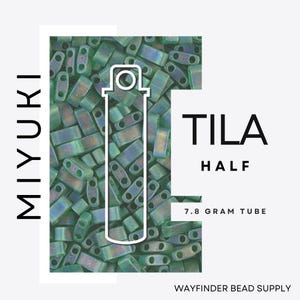 May include: A close-up of a tube of Miyuki Tila beads in a green color with iridescent shimmer. The tube is labeled "Tila Half" and "7.8 gram tube".
