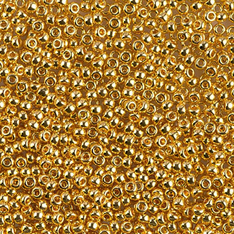 K&ouml;nnte beinhalten: Nahaufnahme einer gro&szlig;en Menge kleiner, runder, goldfarbener Perlen. Die Perlen haben eine gl&auml;nzende, metallische Oberfl&auml;che.