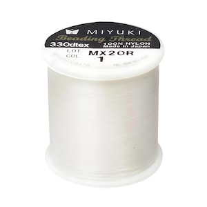 May include: A white spool of Miyuki Beading Thread, 330dtex, 100% nylon, made in Japan. The label reads "Miyuki Beading Thread 330dtex 100% Nylon Made in Japan" and "MX20R 1".