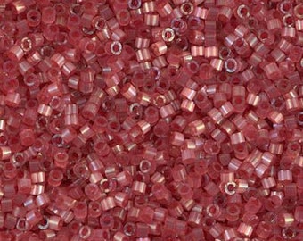 May include: A collection of small, cylindrical glass seed beads in a translucent rose-pink hue. Each bead features a central hole and a smooth, reflective surface with a subtle iridescent finish, creating a uniform texture across the entire display.