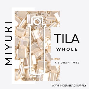 May include: A close-up of a collection of small, rectangular, light-colored beads. The word "MIYUKI" is printed vertically on the left side. The words "TILA WHOLE" are printed on the right side, with "7.2 GRAM TUBE" below. The Wayfinder Bead Supply logo is at the bottom.