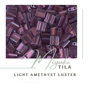 May include: A close-up image of a pile of small, iridescent purple glass beads. The beads are square shaped with a hole in the center. The beads are labeled "Miyuki Tila Light Amethyst Luster".