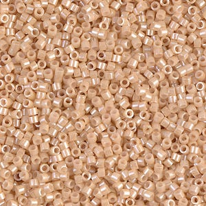 May include: A close-up view of a pile of small, cylindrical beads. The beads are a light beige color with a subtle pearlescent sheen. They are evenly distributed, filling the frame and suggesting a craft or jewelry-making theme.