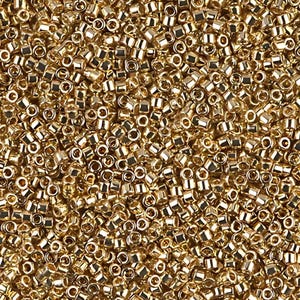 May include: A close-up image of a large quantity of small, gold-colored seed beads. The beads are round and have a shiny finish.