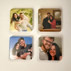 May include: Four square coasters, each featuring a different photograph of a couple. The images are vibrant and show the couple in various settings, including outdoors and indoors. The coasters have a glossy finish.