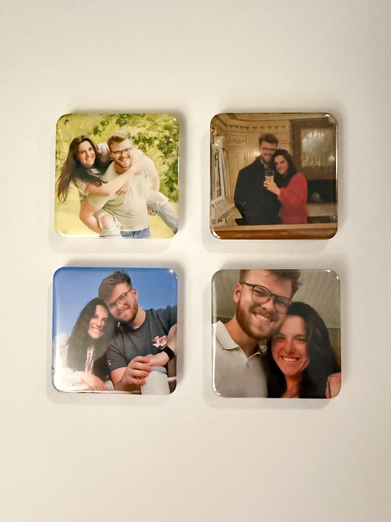 May include: Four square coasters, each featuring a different photograph of a couple. The images are vibrant and show the couple in various settings, including outdoors and indoors. The coasters have a glossy finish.