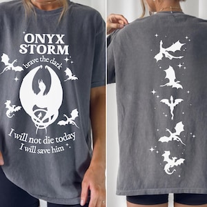 May include: A gray t-shirt with a white graphic print of a dragon and the text "ONYX STORM brave the dark I will not die today I will save him."