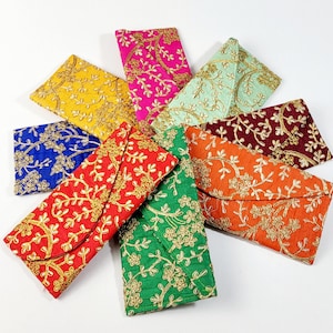 May include: A selection of embroidered clutch purses in various colours. The purses are in red, yellow, blue, green, orange, pink, and burgundy. Each purse features a gold floral design.