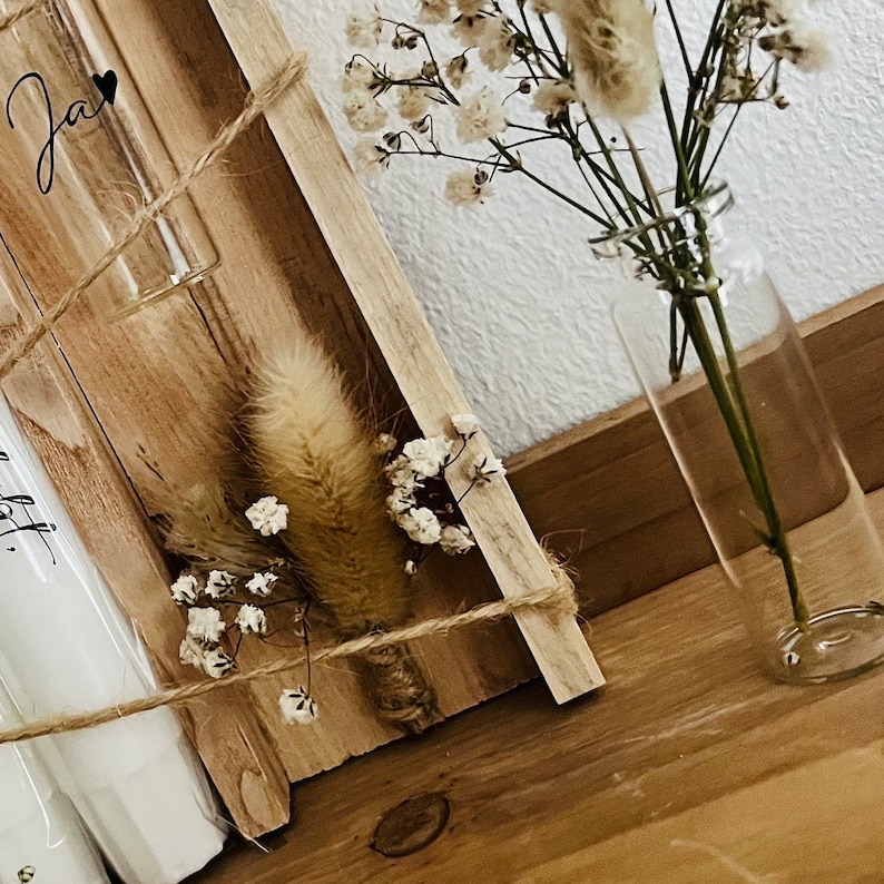 May include: A wooden box with two glass test tubes, one with a small bouquet of dried white flowers and a fluffy brown dried flower, and the other with a handwritten note. The box is tied with twine and the flowers are in a clear glass vase.