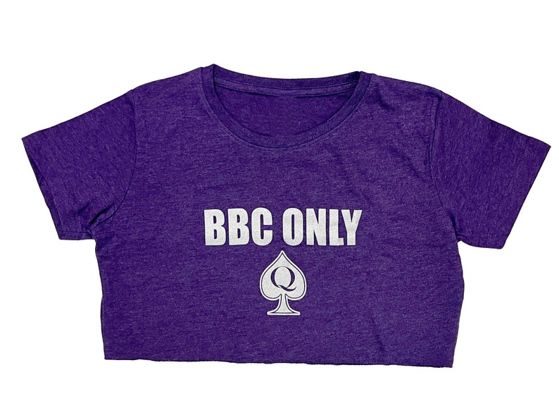 Pu&ograve; includere: Maglietta corta viola con il testo "BBC ONLY" in lettere bianche e un'assegno bianco con una "Q" al suo interno.