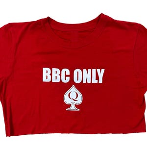 Pu&ograve; includere: Top corto rosso con testo bianco che dice "BBC ONLY" e un simbolo bianco di regina di picche.