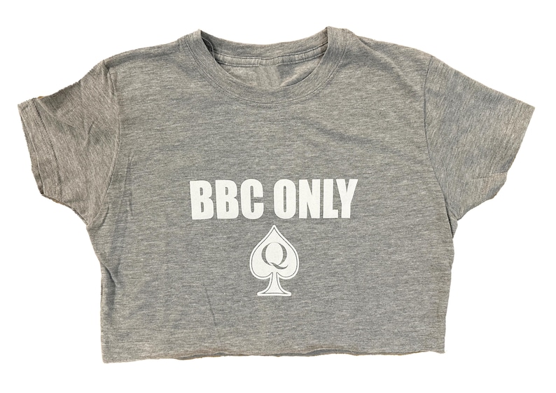 Pu&ograve; includere: Una maglietta grigia a taglio corto con il testo "BBC ONLY" in lettere bianche e un simbolo di picche bianco con una "Q" al suo interno.