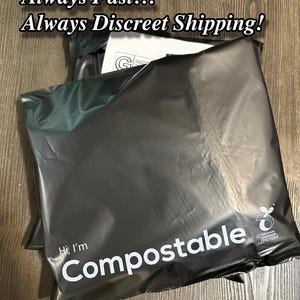 K&ouml;nnte beinhalten: Schwarzer kompostierbarer Versandbeutel mit dem Text "Hi, I'm Compostable" und einem Logo mit dem Text "Home Compostable 7P01084".