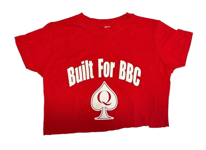 K&ouml;nnte beinhalten: Rotes, bauchfreies T-Shirt mit wei&szlig;em Text "Built For BBC" und einer wei&szlig;en Pikkarte mit einem "Q" darin.