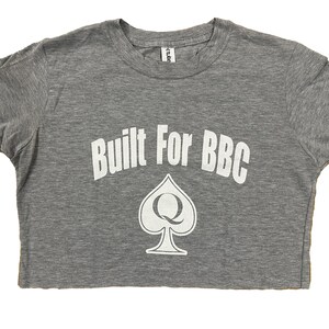 K&ouml;nnte beinhalten: Graues Crop-Top mit dem Text "Built For BBC" und einem wei&szlig;en Pik mit einem "Q" darin.