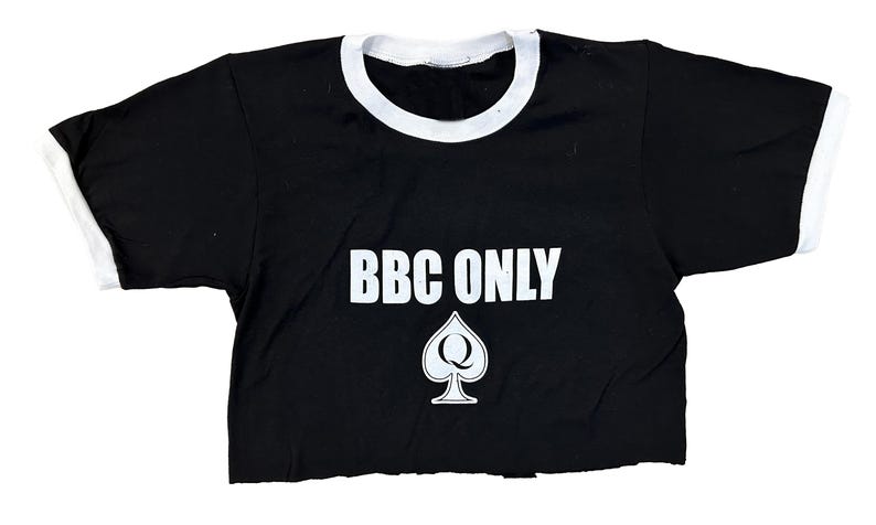 Pu&ograve; includere: Maglietta nera e bianca con collo a contrasto con il testo "BBC ONLY" e un'assegno bianco con una "Q" al suo interno.