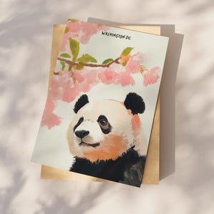 Charming Washington DC postcard featuring a whimsical watercolor and ink illustration of a giant panda lounging under blooming cherry blossom trees. A delightful National Mall souvenir, perfect for panda lovers, cherry blossom fans, and DC visitors.