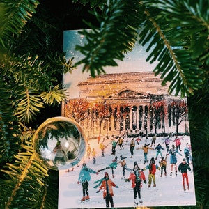 Washington DC Christmas postcard featuring a festive illustration of ice skaters at the National Gallery Sculpture Garden Ice Rink with snowy trees and holiday lights. Perfect DC holiday souvenir, Christmas greeting card, winter travel keepsake, or New Year postcard. Printed on luxe 4x6 matte cardstock, locally made in Washington DC & Virginia. Great for holiday decor lovers, DC travelers, and postcard collectors.