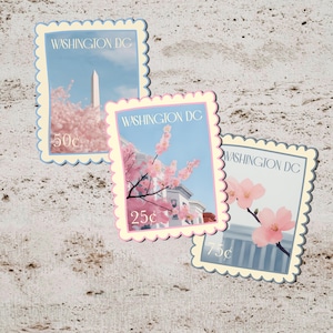 May include: Three postage stamp-style stickers featuring Washington DC landmarks and cherry blossoms. Each sticker has a scalloped edge and a different denomination: 50¢, 25¢, and 75¢. The background is a light beige, textured surface.