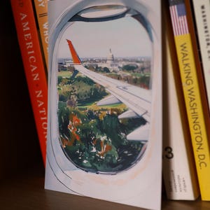 Hand-drawn Washington DC postcard featuring watercolor and ink illustration with the US Capitol Building seen from the airplane window. Elegant 4x6 postcard with watercolor-style artwork, perfect for Washington DC tourists, DC locals, collectors, post crossers, and travel souvenirs collectors.