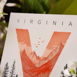 Virginia postcard featuring the letter "V" artistically intertwined with lush forests and majestic mountain peaks. A perfect 4x6" Virginia souvenir celebrating the state’s natural beauty. Printed on premium matte cardstock, ideal for nature lovers, hikers, and adventure seekers.
