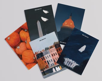 Puede incluir: Un conjunto de postales de Halloween con ilustraciones de monumentos de Washington D.C. y fantasmas. Las postales muestran el Monumento a Washington, el Capitolio, la Casa Blanca y coloridas casas adosadas, con el texto "BOO FROM DC".