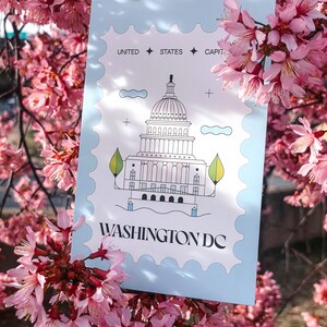 Modern minimalist Washington DC postcard featuring a postage stamp-inspired illustration of the US Capitol on a sky-blue background. A stylish and unique Washington DC travel souvenir, political art print, or collector’s item. High-quality 4x6 postcard, perfect for sending or displaying