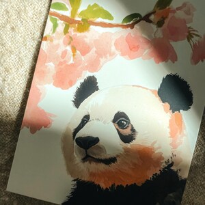 Charming Washington DC postcard featuring a whimsical watercolor and ink illustration of a giant panda lounging under blooming cherry blossom trees. A delightful National Mall souvenir, perfect for panda lovers, cherry blossom fans, and DC visitors.