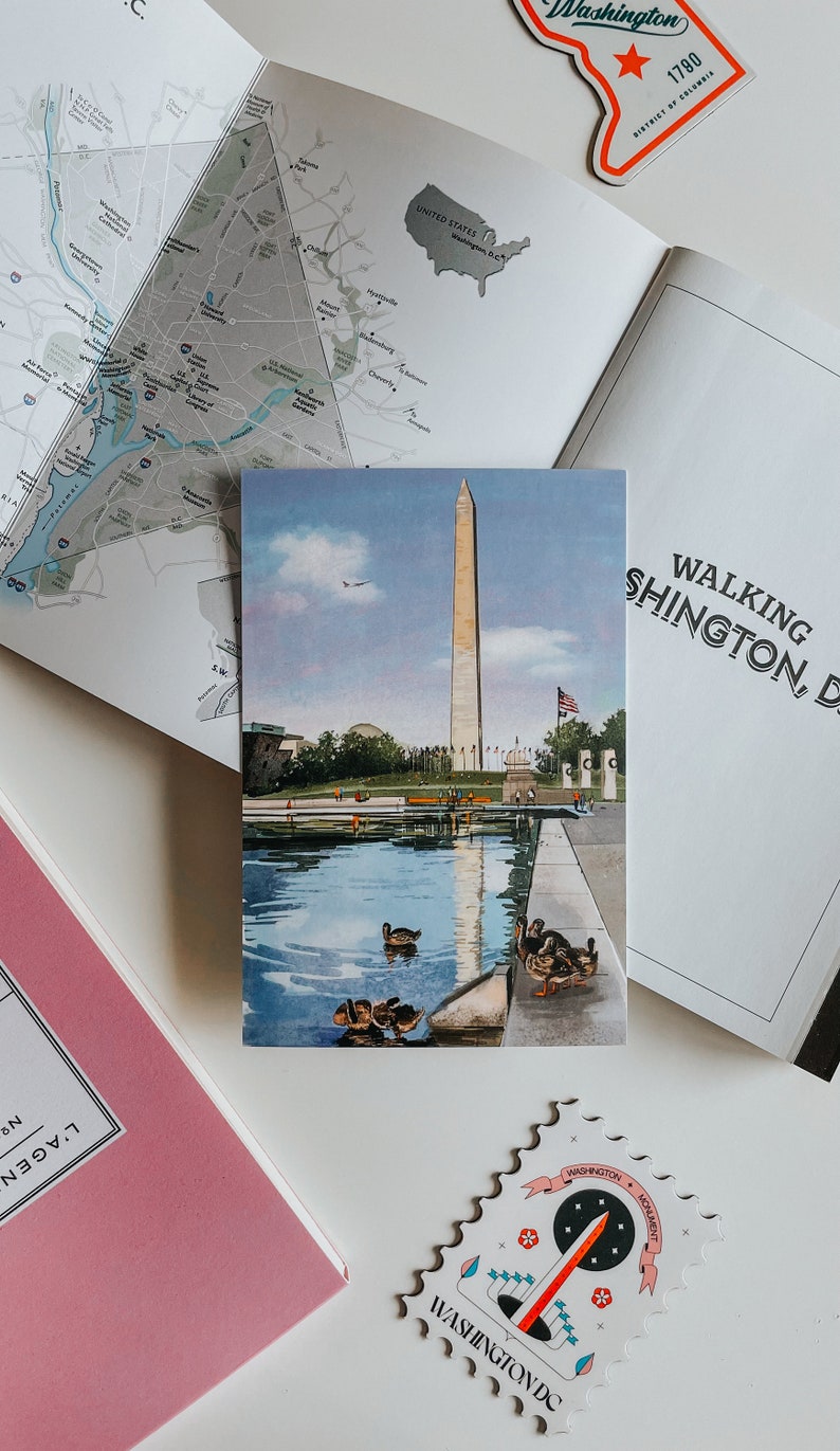 Hand-painted watercolor and pen illustration postcard of The Washington Monument in Washington, DC, featuring a charming duck family swimming in the Reflecting Pool. A whimsical and artistic postcard, perfect as a DC travel souvenir or gift for nature lovers.
