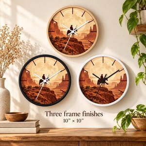May include: Three round wall clocks with light wood, black, and white frames. Each clock face features a desert landscape with a cowboy on horseback under a full moon. The text Three frame finishes 10" x 10" is printed below the clocks.