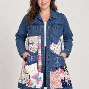 May include: A long-length blue denim jacket featuring a button-down front, two chest pockets, and a patchwork design on the lower panels. The patches include floral patterns, plaid fabric, a butterfly print, and hand-drawn peace signs and text.