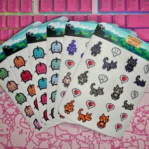May include: A set of five sticker sheets featuring pixel art designs from the video game Stardew Valley. The sheets include characters, items, and other elements from the game. The sheets are printed on white paper with a glossy finish.