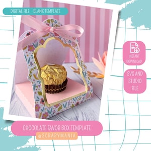 Puede incluir: Una plantilla de caja de regalo de chocolate rosa y con estampado floral con una ventana con ribete dorado, que contiene un caramelo de chocolate envuelto. La caja está atada con una cinta rosa. El texto en la imagen incluye "DIGITAL FILE - BLANK TEMPLATE" y "CHOCOLATE FAVOR BOX TEMPLATE".
