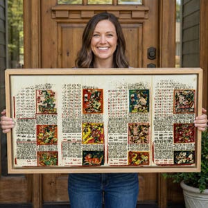 May include: A framed artwork with Mayan glyphs and illustrations in a light-coloured wooden frame. The artwork has a cream background with red, green, and yellow accents. The artwork is held by a person. The artwork is a piece of art.
