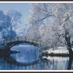 Può includere: Un ponte di legno su un lago ghiacciato in una foresta innevata. Gli alberi sono ricoperti di neve e l'acqua è di un blu profondo. La scena è pacifica e serena.