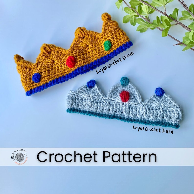 On a white background lies one golden, crocheted crown with a blue trim and crocheted jewels in royal blue, red and green and one silver grey, crocheted tiara with a teal trim and crocheted jewels in blue, red and teal yarn.