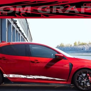 Könnte beinhalten: Ein roter Honda Civic Type R mit weißen und schwarzen Rennstreifen an der Seite. Das Auto befindet sich auf einer Rennstrecke mit einer grauen Betonwand im Hintergrund.