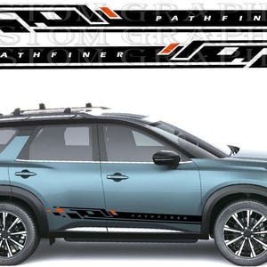 May include: A blue SUV shown in profile view with black and orange geometric side decals applied to the lower doors. The decals feature the text PATHFINER in a bold font, accompanied by a set of matching graphic stickers displayed above the vehicle.