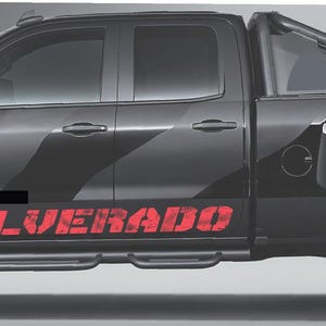 以下が含まれることがあります： 黒いシルバラードのピックアップトラック。黒いホイールと側面に赤い「SILVERADO」の文字。トラックは黒いストライプのデザインと荷台の上にロールバーがあります。